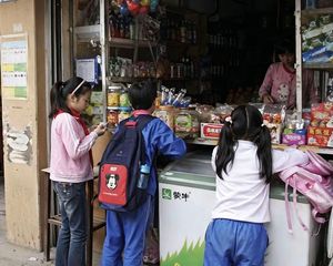Chinese primary school students previewing an image at a corner shop.