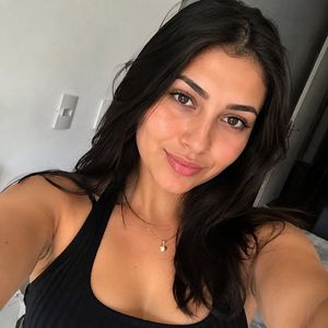 Realistic female selfie preview image against an urban backdrop